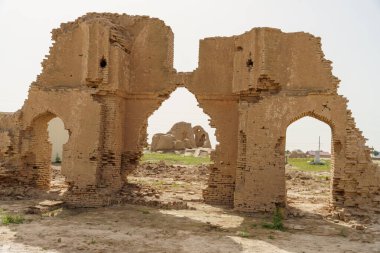 İki kavisli girişi olan büyük, çökmüş bir bina.