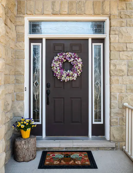 Evin ön kapısı bahar için çelenk ve çiçeklerle süslenmiş..