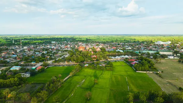 Akşamları hava manzarası, köy pirinç tarlalarıyla çevrilidir.
