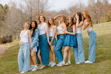 Üniversite öğrencileri çimenlikte birlikte poz veriyor.