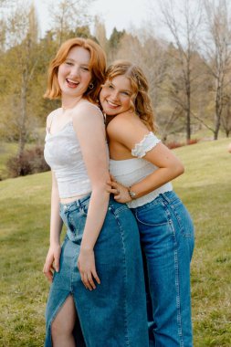 Üniversitede arkadaşlığı kucaklayan iki genç kız.