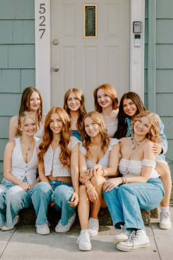 Bir grup üniversite öğrencisi basamaklarda birlikte poz veriyor.