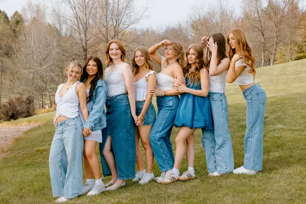 Üniversite öğrencileri çimenlikte birlikte poz veriyor.