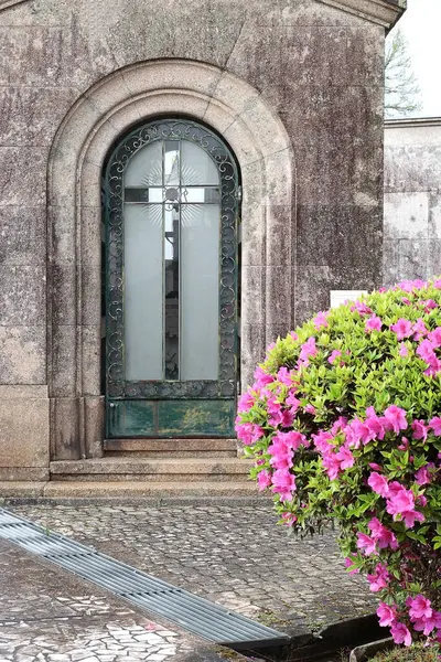 Demir haçlı ve çiçekli eski kemerli kapı.