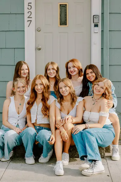 Bir grup üniversite öğrencisi basamaklarda birlikte poz veriyor.