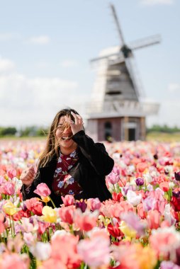 Hollanda Bahçesinde Renkli lalelerle çevrili Gülen Kadın
