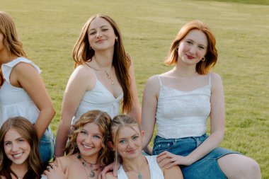 Z nesli üniversite öğrencileri kampüs bahçesinde birlikte gülümsüyor.