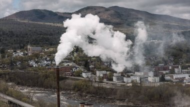 Arka planda konut alanı olan gaz yayan duman yığını