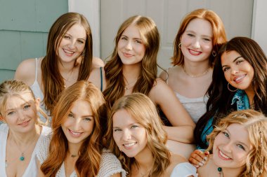 Üniversite öğrencileri kampüste birlikte gülümsüyor.