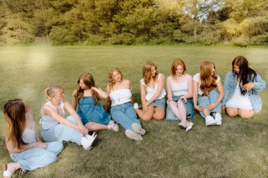 Üniversite öğrencileri kampüs bahçesinde birlikte dinleniyorlar.