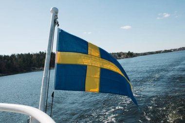 Stockholm 'de bir feribotta rüzgarda dalgalanan İsveç bayrağı