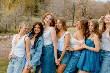 Üniversite öğrencileri açık havada birlikte poz veriyor.