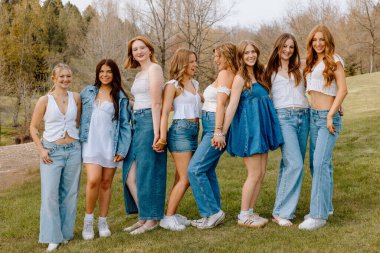 Kot ve beyaz kıyafetler giyen Z nesli üniversite öğrencileri.