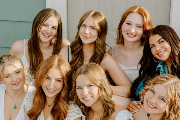 Üniversite öğrencileri kampüste birlikte gülümsüyor.