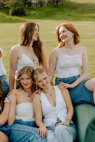 Z nesli üniversite öğrencileri kampüs bahçesinde birlikte gülümsüyor.