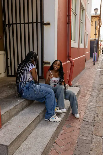 Sokakta kahve içen kız kardeşler.