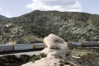 Bir tren eşsiz bir kaya oluşumunun altından geçer.
