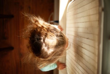 Genç bir kızın üstünde uzun sarı bukleler haykırıyor.