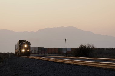Gün batımında bir tren yaklaşıyor.