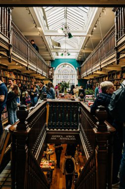 Ahşap iç ve tavan penceresi olan iki katlı kalabalık bir kitapçı.