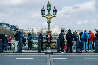 İskoç kıyafetli sokak sanatçısı Londra kalabalığı için gayda çalıyor.