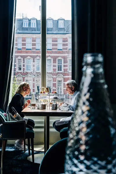 Çift şık bir ortamda öğleden sonra çayının keyfini çıkarıyor.