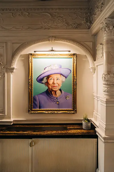 Süslü iç bölme aydınlatmasında çerçevelenmiş kraliyet portresi