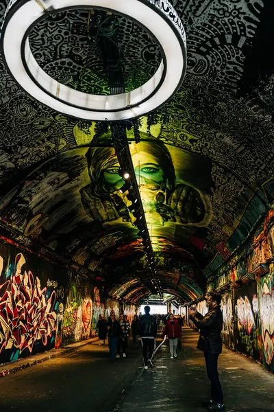 Kemancı duvar yazısı dolu bir tünelde duvar resmi tavanlı performans sergiliyor.
