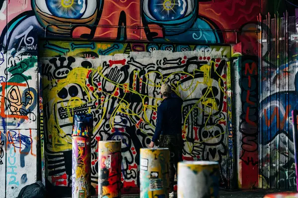 Ressam şehir duvarına renkli graffiti yapıyor.