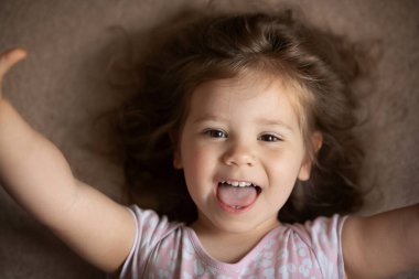 Mutlu çocuk kız yatakta yatarken gülüyor..