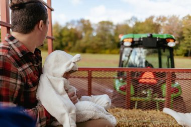 Baba ve bebek mısır labirentinde samanlıkta geziyorlar.
