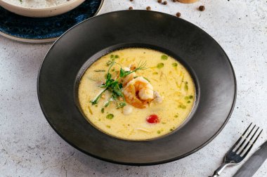 Bir restoranda karides ve otlu kremalı çorba.