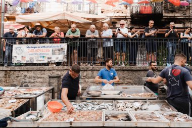 Sicilya 'da bir balık pazarında taze balık ve turist satıcıları.