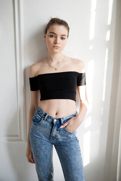 Portrait of a young woman in a top and jeans