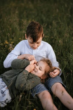 Ablası kardeşinin kucağına yatar ve güler.