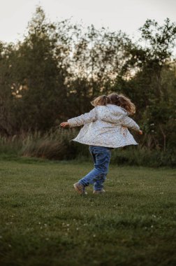 Kız parkta dönüyordu da. Kollarını uzatıyor. İlkbahar.