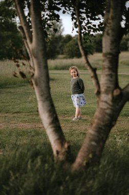 Kız parkta iki bavul arasında kalıyor ve kameraya bakıyor..