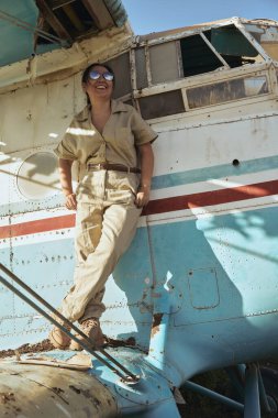 Uçuş elbisesi içindeki kadın, gülümsüyor.