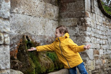 Çocuk dereden su alıyor..