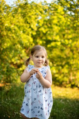 Parkta dikilip gözlerini kaçıran düşünceli bir genç kız. yaz.