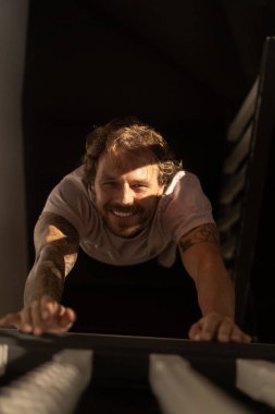 Genç sakallı, gülümseyen bir adamın portresi.