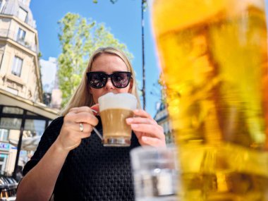 Paris 'teki açık kafede latte macchiato içen bir turist