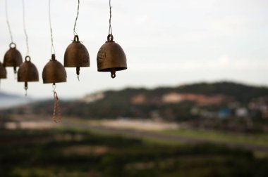 Manzaralı bir vadiye bakan çanlar asılı.