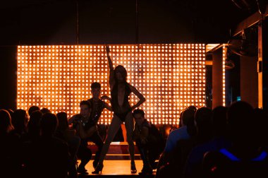 Sahne ışıkları altında ateşli bir poz.