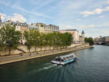 Turist teknesi, sen nehrinde insanlar dinlenirken.