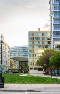 Günbatımında yeşil çimenli ve sokak elementli modern cam binalar