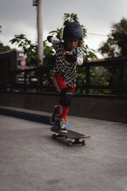 Kaykay yapan bir çocuk kaykay parkında eğleniyor.