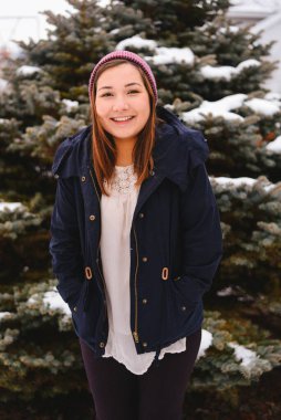 Genç kadın gülümsüyor ve kış harikalar diyarının tadını çıkarıyor