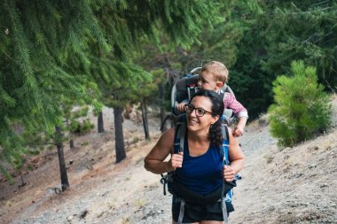 Annesi kasabanın dışında bir patikada yürür. Bebeğini sırtında taşır.