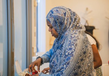 Modern ofiste öğle yemeği sırasında tesettürlü Müslüman kadın yemek yiyor